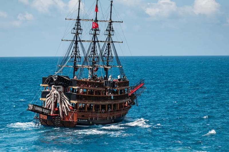 Alanya: Pirate Boat with Transfer, Lunch & Unlimited Drinks - Red Tower, shipyard, and castle from the harbor