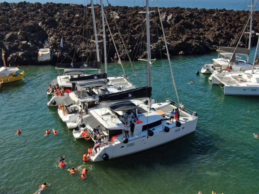 Santorini: Catamaran Cruise with Meal & Open Bar - The lighthouse, Black Mountain, and the caldera