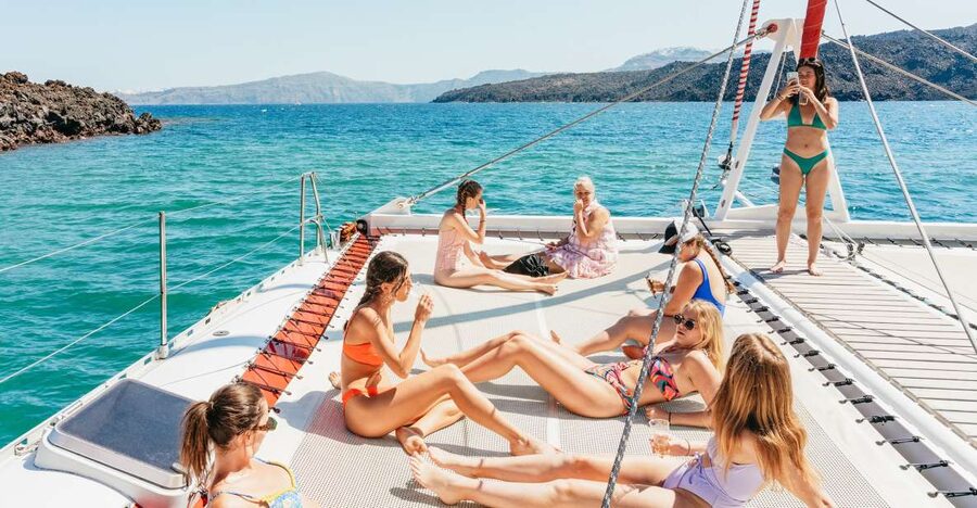 Santorini: Catamaran Tour with BBQ Dinner, Drinks, and Music - Red Beach from the water