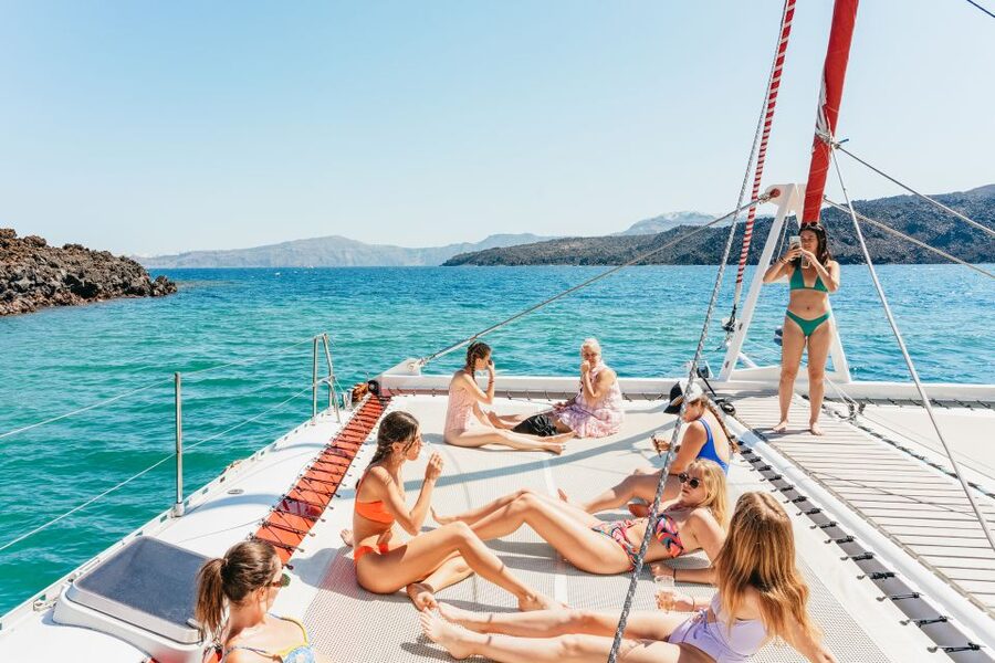 Santorini: Catamaran Tour with BBQ Dinner, Drinks, and Music - White Beach beneath the cliffs