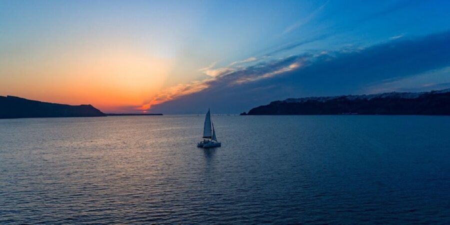 Santorini: Sunset Cruise with Swim Stops, Dinner, and Drinks - White Beach and Black Mountain Beach from the water